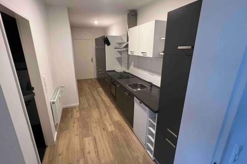 a kitchen with white cabinets and a black counter top at Apartment in Langenhagen-Airport-Hannover! contactless check-in in Hannover