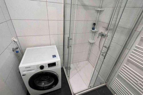 a shower with a washing machine in a bathroom at Apartment in Langenhagen-Airport-Hannover! contactless check-in in Hannover