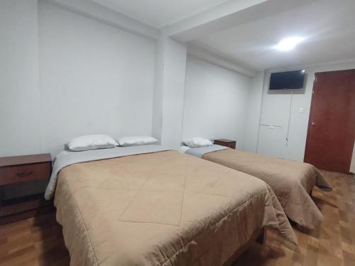 een slaapkamer met 2 bedden in een kamer bij Yuraq Wasi Hostal in Ayacucho