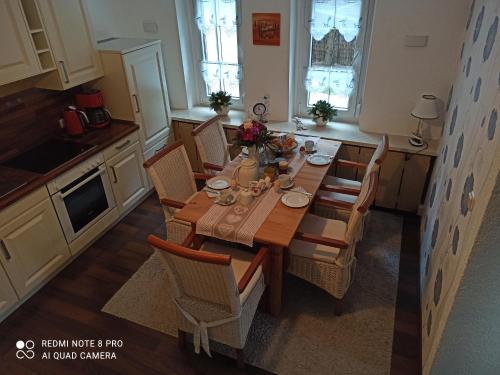 a kitchen with a wooden table and chairs at Ferienwohnung"Harzliebe" in Gernrode - Harz