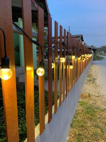 a fence with lights on the side of a building at KHUN CHUAT'S HOUSE in Ban Nong Ben
