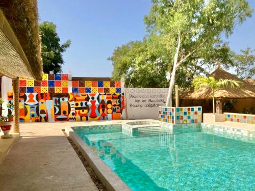 a swimming pool in front of a colorful fence at La Maison Chocolat in Nianing