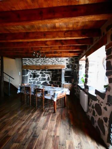 a room with a stone fireplace and a table at Maison entière située à proximité du centre thermal de Chaudes-Aigues in Espinasse