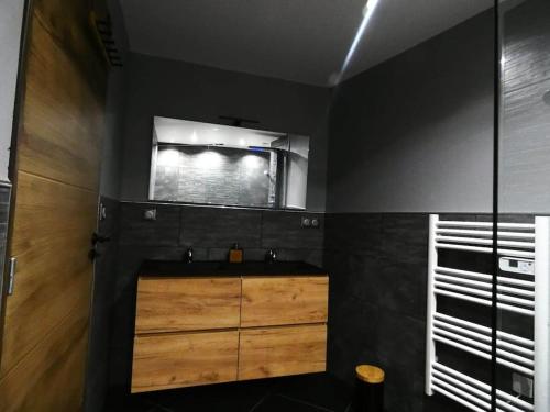 a bathroom with a wooden sink and a mirror at Maison entière située à proximité du centre thermal de Chaudes-Aigues in Espinasse