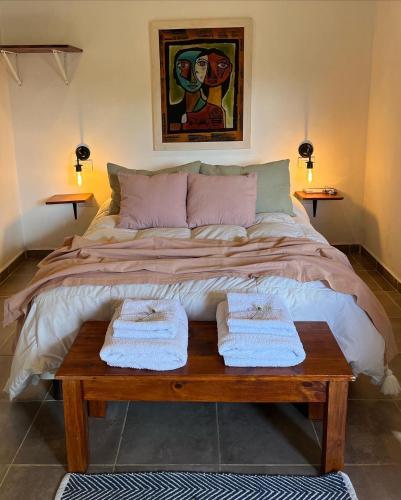1 cama grande con 2 toallas sobre una mesa de madera en Bernalina Monoambiente en Villa Berna