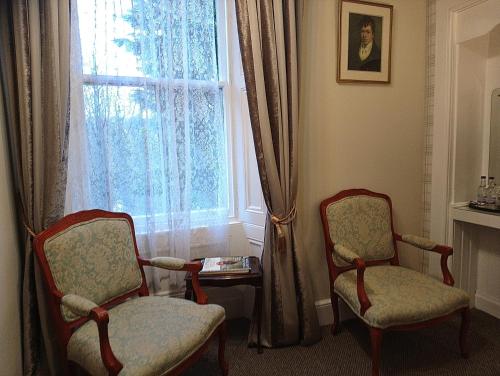 two chairs sitting in front of a window at Heatherlie House Hotel in Selkirk