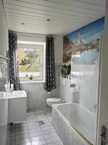 uma casa de banho com uma banheira, um WC e um lavatório. em Ferienwohnung Allgäu 2 em Memmingen