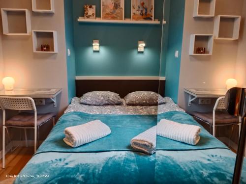 a bed in a room with blue walls and two chairs at Uroczy Apartament Długie Ogrody 48 in Gdańsk