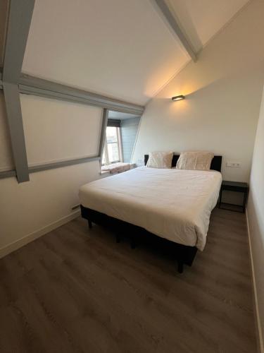 a bedroom with a large white bed in a room at Appartement Warmond in Warmond