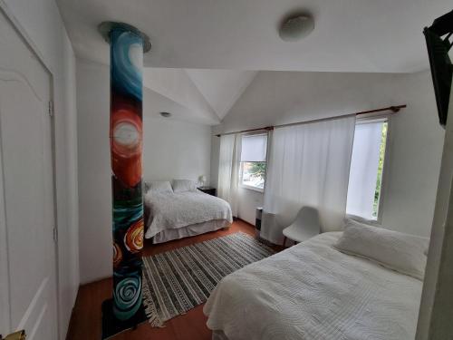 1 Schlafzimmer mit 2 Betten und einem großen Fenster in der Unterkunft Hostal Casa Arrayán in Coihaique