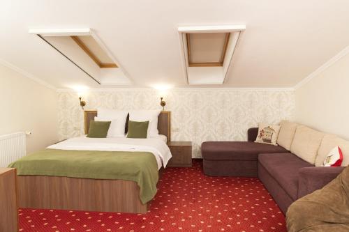 een hotelkamer met een bed en een bank bij Pensiunea Noblesse in Baile Felix