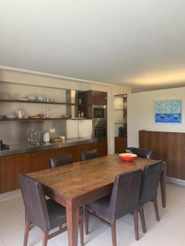a dining room table with chairs and a kitchen at Salgados - Vila das lagoas, Beach & Golf in Albufeira