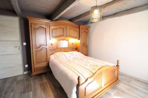 a bedroom with a wooden bed with a wooden headboard at Maison entière située à proximité du centre thermal de Chaudes-Aigues in Espinasse