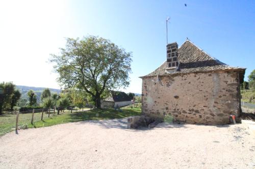 an old building with a tower on a dirt road at Maison entière située à proximité du centre thermal de Chaudes-Aigues in Espinasse