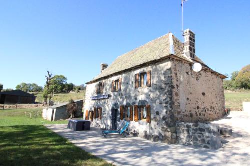 an old stone building with a bench in front of it at Maison entière située à proximité du centre thermal de Chaudes-Aigues in Espinasse