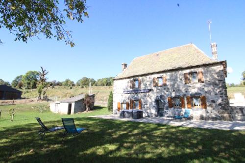 an old stone house with a bench in the yard at Maison entière située à proximité du centre thermal de Chaudes-Aigues in Espinasse