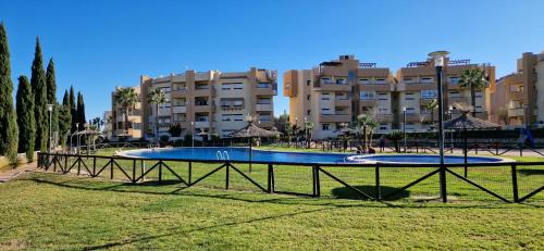 a swimming pool in a park in front of a building at Tranquila y bonita casa in Murcia