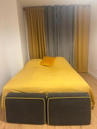 Una cama en una habitación con una manta amarilla. en Apartament Kiekrz 2 Air Port 5 minut, en Baranowo
