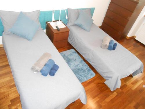 2 łóżka pojedyncze w pokoju z niebieskimi poduszkami w obiekcie Casa Vacanze NATASCIA w Trieście