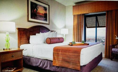 a hotel room with a bed and a window at Tahiti Village in Las Vegas