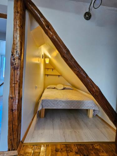 a small bedroom with a bed in a attic at Ziediņi in Auciems