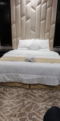 1 dormitorio con 1 cama blanca grande y cabecero grande en درر بيان, en Hafr Al Batin