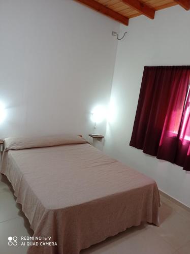 Schlafzimmer mit einem Bett und einem roten Fenster in der Unterkunft Complejo Valhalla 4 a 300 mts de la PLAYA in Mar Azul