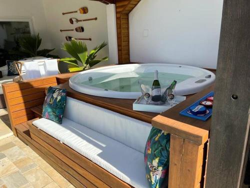 eine Whirlpool-Badewanne mit einem Tablett mit Weingläsern in der Unterkunft Linda casa em Barra do Una in São Sebastião