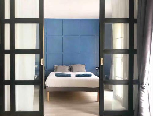 um quarto com uma cama com uma parede azul em Loft Catedral em Burgos
