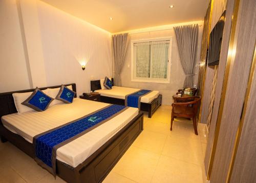 Cette chambre comprend deux lits et un bureau. dans l'établissement Phuc Hotel, à Cao Lãnh