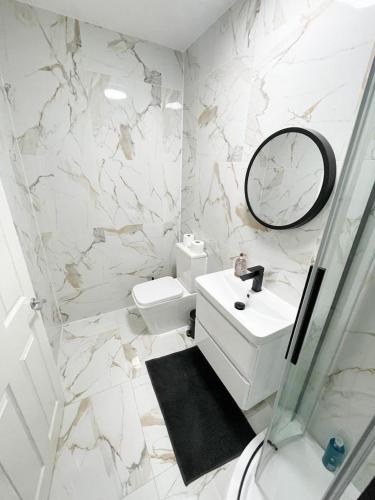 a white bathroom with a sink and a mirror at Luxury Stylish studio Flat +spacious Bathroom-no 6 in Leicester