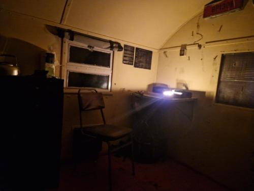 a dark room with a chair and a window at Bushcraft survival nocleg dla samca alfa 