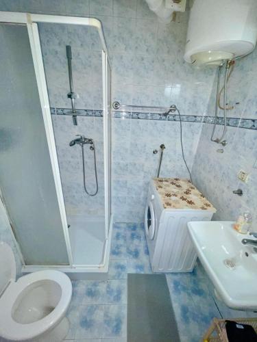 ein Badezimmer mit Dusche, Toilette und Waschbecken in der Unterkunft Slavija McD apartment in Belgrad