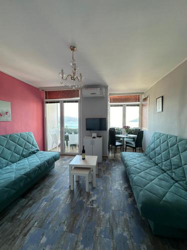 a living room with two green couches and a table at Sea Apartment Igalo in Herceg-Novi