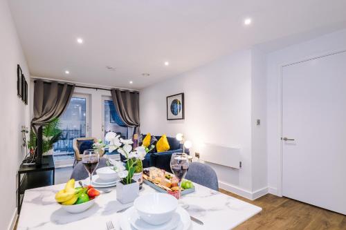 a dining room and living room with a table and chairs at Waterhouse Suite - Modern 2 Bed in Manchester City Centre- Perfect for Family, Business and Leisure Stays by Dreamluxe in Manchester