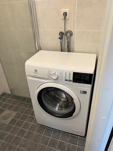 een wasmachine en droger in een hoek van een badkamer bij Small studio apartment in Tallinn
