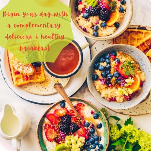 a table topped with plates of breakfast food with a sign at Paradise Palms in San Juan