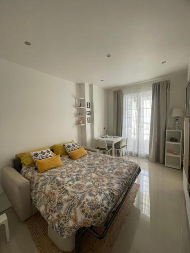 une chambre avec un grand lit avec des oreillers jaunes dans l'établissement Bright apartment at Mimi’s, à Nice