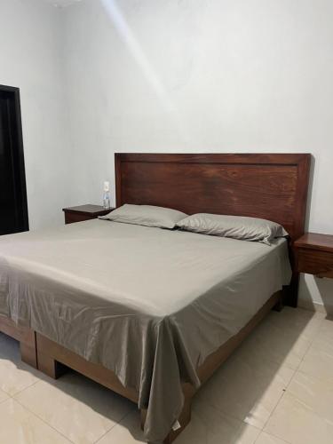 a bed with a wooden headboard in a bedroom at Casa de la esquina in Santa María del Oro