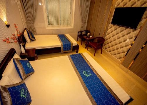 a hotel room with two beds and a television at Phuc Hotel in Cao Lãnh