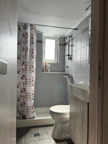 a bathroom with a toilet and a shower curtain at Emerald Cozy Apartment in Rhodes Town
