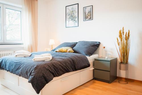 - une chambre avec un lit et des serviettes dans l'établissement Moderne 3-Zimmer-Wohnung in Top-Lage, à Karlsruhe