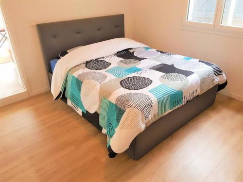 un lit avec une couette dessus dans une chambre dans l'établissement Superbe appartement dans villa provençale piscine et jardin, à Fréjus