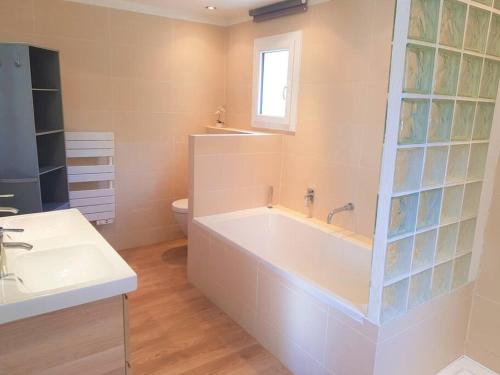 une salle de bain blanche avec une baignoire et un lavabo dans l'établissement Superbe appartement dans villa provençale piscine et jardin, à Fréjus