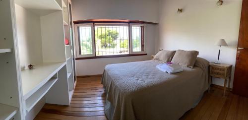 1 dormitorio con cama y ventana en Santa Cruz 5761 en Mar del Plata