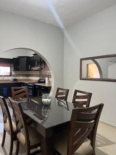 a dining room with a black table and chairs at Casa de la esquina in Santa María del Oro