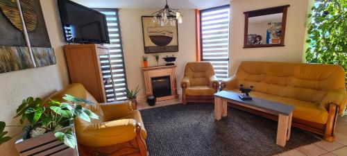 a living room with a couch and a table at Hôtel L'Etoile Aéroport - A61 in Carcassonne