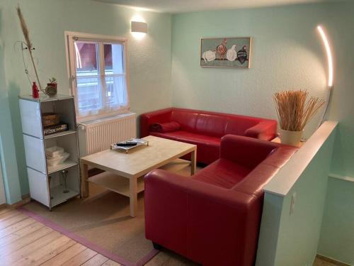 sala de estar con sofá rojo y mesa en TinyHome_Haus_Helene, en Bad Honnef am Rhein