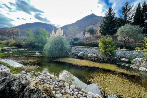 a pond in a garden with mountains in the background at Masseria boutique b&b in Montella