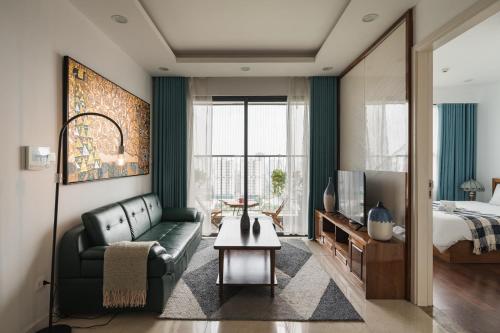 - un salon avec un canapé et un lit dans l'établissement Troy House - Serviced Apartment - DCapitale, à Hanoï
